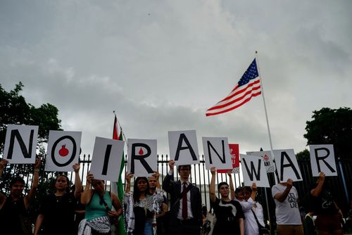 Demonstrators hold signs during a protest against war with Iran outside the White House in Washington, DC, US, on Wednesday, June 18, 2025. President Donald Trump concluded a meeting Wednesday with top advisers as he weighed whether to plunge the US into the ongoing war between Israel and Iran, but the White House offered few clues about whether he had decided to join the offensive aimed at destroying Tehrans nuclear program. Photographer: Kent Nishimura/Bloomberg