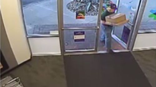 Mark Anthony Conditt enters a FedEx store in a wig.