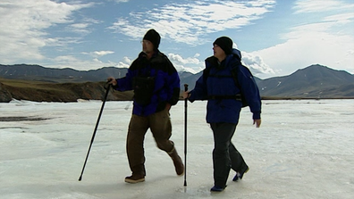 Liz Hayes and guide cross frozen river in Alaska.