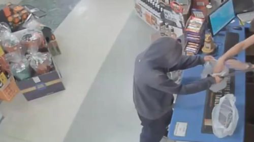 CCTV captured the robber demanding cash. (Victoria Police)