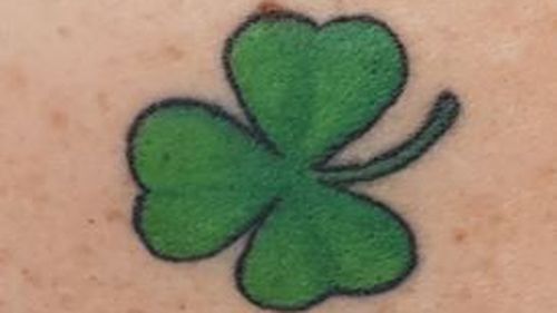 The woman has a clover tattoo on her shoulder.