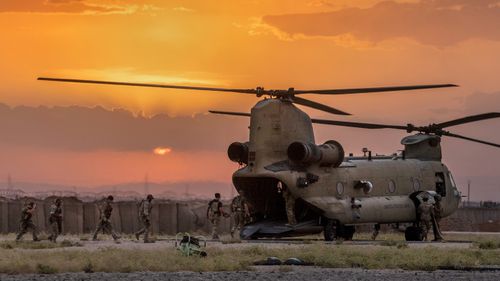 US Army soldiers board a CH-47 Chinook helicopter while departing a remote combat outpost known as RLZ near the Turkish border in northeastern Syria.
