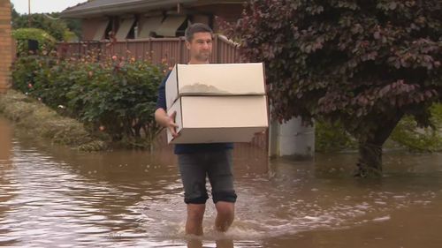 A family waded through floodwaters to retrieve items from their home.