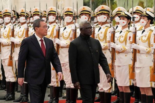 Il primo ministro delle Isole Salomone Manasseh Sogavare, a destra, e il suo omologo cinese Li Qiang esaminano la guardia d'onore durante una cerimonia di benvenuto presso la Grande Sala del Popolo a Pechino, lunedì 10 luglio 2023.  