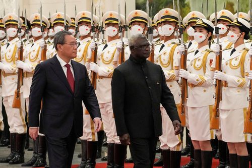 Visiting Solomon Islands Prime Minister Manasseh Sogavare, right, and his Chinese counterpart Li Qiang review an honor guard during a welcome ceremony at the Great Hall of the People in Beijing, Monday, July 10, 2023.  