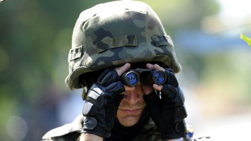 A member of Ukrainian volunteer battalion 'Dnipro' looks through binoculars near the small southern Ukrainian city of Novoazovsk. (AFP)