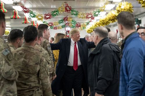 President Donald Trump visits with members of the military at a dining hall at Al Asad Air Base, Iraq.