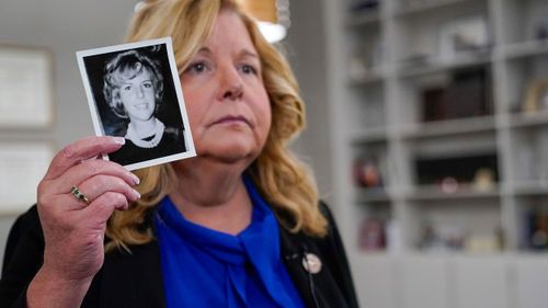 Nassau County District Attorney Anne Donnelly holds a photo of Diane Cusick during an interview with The Associated Press, Wednesday, June 22, 2022, in Mineola, N.Y.