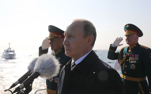 
Russian President Vladimir Putin (C), Russian Defence Minister Sergei Shoigu (L) and Western Military District Commander Col. Gen Andrei Kartapolov (R) during the naval parade. (AAP)