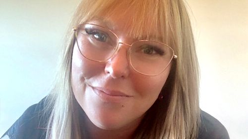 Ashlee Law, una donna bionda con gli occhiali, sorride alla telecamera in un primo piano.