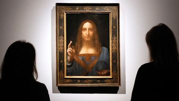 People gather around Leonardo da Vinci&#x27;s &quot;Salvator Mundi&quot; on display at Christie&#x27;s auction rooms in London, in 2017.