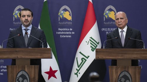 Syrian Foreign Minister Asaad al-Shaybani, left, speaks during a news conference with his Iraqi counterpart Fouad Hussein following their meeting, in Baghdad, Iraq, Friday, March.14, 2025. (AP Photo/Hadi Mizban)