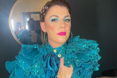 Em Rusciano poses in a blue ensemble.