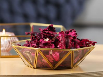 Aromatic potpourri of dried flowers in decorative bowl and burning candles on table indoors, space for text