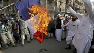Supporters of religious group burn a representation of a French flag during a rally against French President Emmanuel Macron and republishing of caricatures of the Prophet Muhammad they deem blasphemous, in Karachi, Pakistan, Friday, Oct. 30, 2020