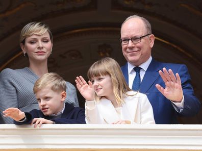 Prince Albert, Princess Charlene, Prince Jacques and Princess Gabriella of Monaco wave from a palace balcony.