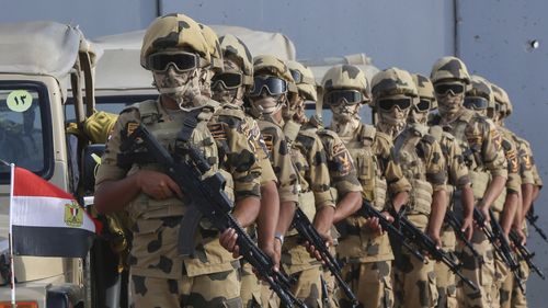 Military personnel stand alert at the Rafah border crossing