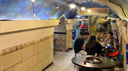 Residents dine in a WWII-era bomb shelter turned hotpot restaurant. Chongqing is known for its hot temperatures and spicy cuisine.