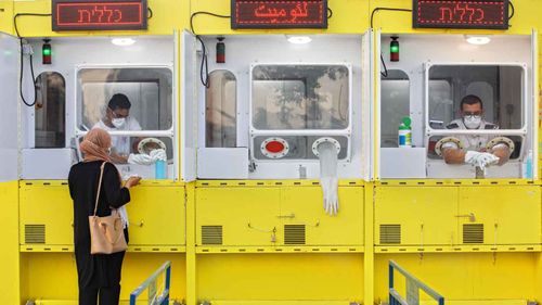 A woman is tested by a healthcare worker for the coronavirus at a mobile testing station, in east Jerusalem.