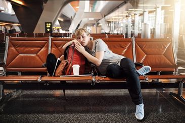 Full length shot of an attractive young woman sleeping in an airport