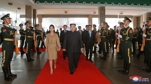 The North Korean leader and his wife get the red carpet treatment in Beijing. Picture: AP