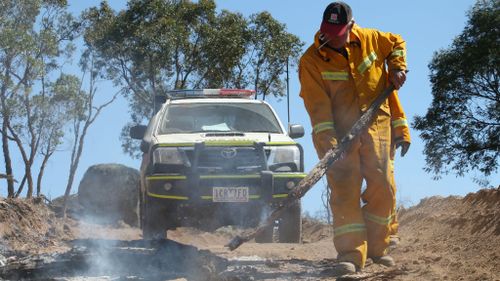 A Country Fire Authority officer clears out a hot spot. (AAP)