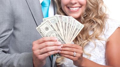 Bride and groom holding money