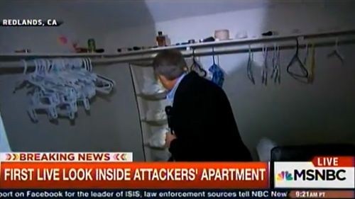 Reporter Kerry Sanders looks through the wardrobe inside the alleged shooters' apartment. (MSNBC)