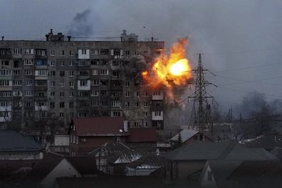 An explosion is seen in an apartment building after Russians army tank fires in Mariupol, Ukraine, Friday, March 11, 2022. (AP Photo/Evgeniy Maloletka)