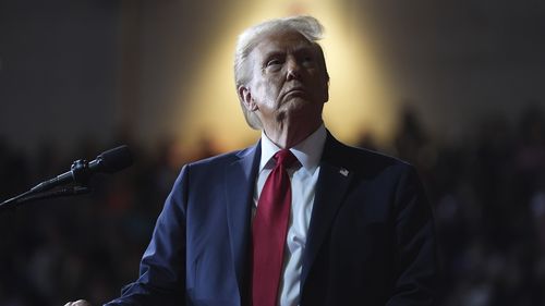 President Donald Trump watches a video screen at a campaign rally.