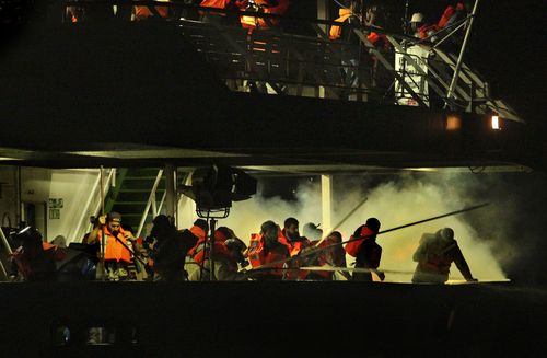 I passeggeri sul secondo ponte della nave passeggeri turca Mavi Marmara corrono circondati dal fumo dei gas lacrimogeni sparati dalle navi d'assalto israeliane poco dopo che gli uomini avevano completato la preghiera serale. La marina israeliana ha attaccato 6 navi della Freedom Flotilla dirette a Gaza nelle prime ore di lunedì 31 maggio 2010.