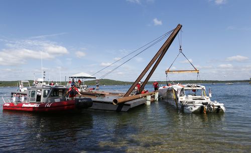 The duck boat that sank in Table Rock Lake in Branson, Mo., is raised Monday, July 23, 2018. The boat went down Thursday evening after a thunderstorm generated near-hurricane strength winds. (Nathan Papes/The Springfield News-Leader via AP)