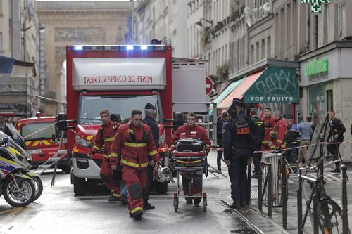 Fire brigade medics work on the scene where a shooting took place in Paris, Friday, Dec. 23, 2022 