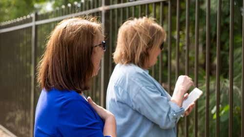 Sisters Joyce Parker and Mary Watson wave to their mother Alice Bacon on April 29.