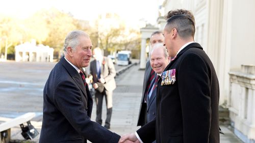 The Prince of Wales is greeted by Colonel Tom Bonas and WSM Dean Morgan as he arrives at the Guards' Memorial at the Guards' Chapel, Wellington Barracks, London. (AAP)