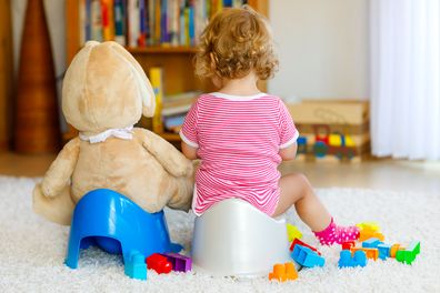 Closeup of cute little 12 months old toddler baby girl child sitting on potty.