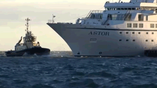 A tug boat helps the Astor cruise ship get free of the St Kilda pier. (9NEWS)