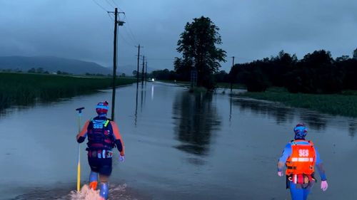SES workers walk through flooded areas near Murwillumbah in the Northern Rivers