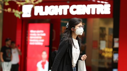 A woman is seen wearing a mask while walking down Murray Street mall on March 27, 2020 in Perth, Australia.