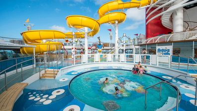 An outdoor circular pool and yellow water slide