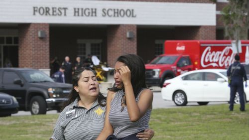 A student is comforted by a school official. (AP)