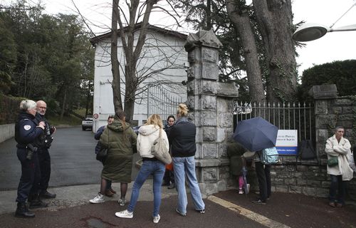 Police officers guard the entrance of a private Catholic school after a teacher has been stabbed to death by a high school student, Wednesday, Feb. 22, 2023 in Saint-Jean-de-Luz, southwestern France. 