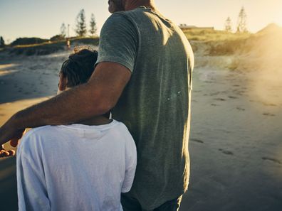 Father and son walking along the beach