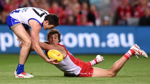 Nathan Grima and Kurt Tippett compete for a loose ball in what was a tough night for North Melbourne's defenders. (AAP)