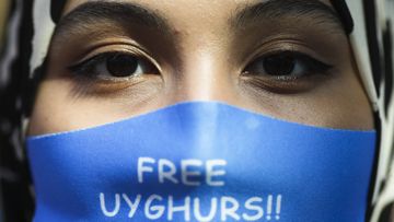 A woman wears a face mask reading &#x27;Free Uyghurs&#x27; as she attends a protest during the visit of Chinese Foreign Minister Wang Yi in Berlin, Germany.