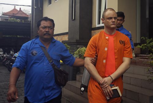 Indonesian police officers escort Australian Isaac Emmanuel Roberts, right, after a press conference in Bali. (AAP)