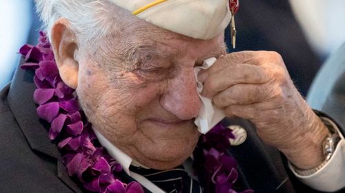 Pearl Harbor survivor Armando "Chip" Galella wipes a tear from his eye after speaking about his experience during a ceremony in New York commemorating the anniversary of the attack on Pearl Harbor. (AAP)