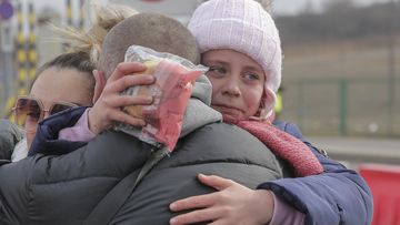 A girl which fled from the war in Ukraine reunites with her father after crossing the border in Medyka, southeastern Poland, Wednesday, March 2, 2022. 