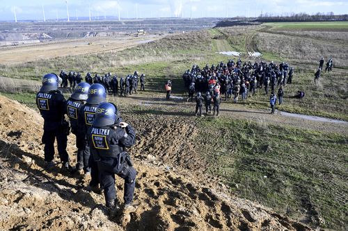 Police officers have surrounded a group of activists and coal opponents on the edge of the Garzweiler II lignite open pit mine during a protest by climate activists following the clearance of Luetzerath, Germany, Tuesday, Jan. 17, 2023.  