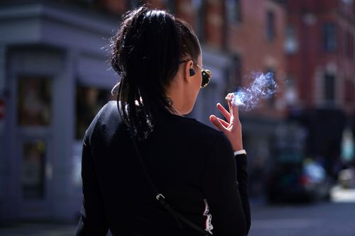 A woman smokes a cigarette.